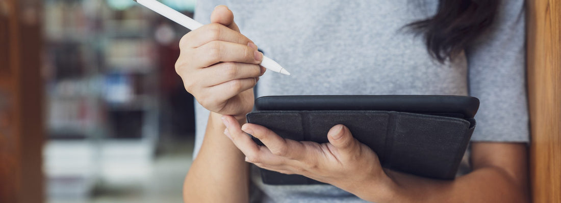 Woman stands with tablet ready to write with tablet pen.