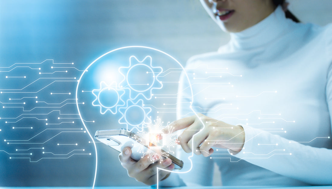 Profile face with cogs turning in foreground, woman with phone symbolising teacher using ChatGTP in the classroom in the background.